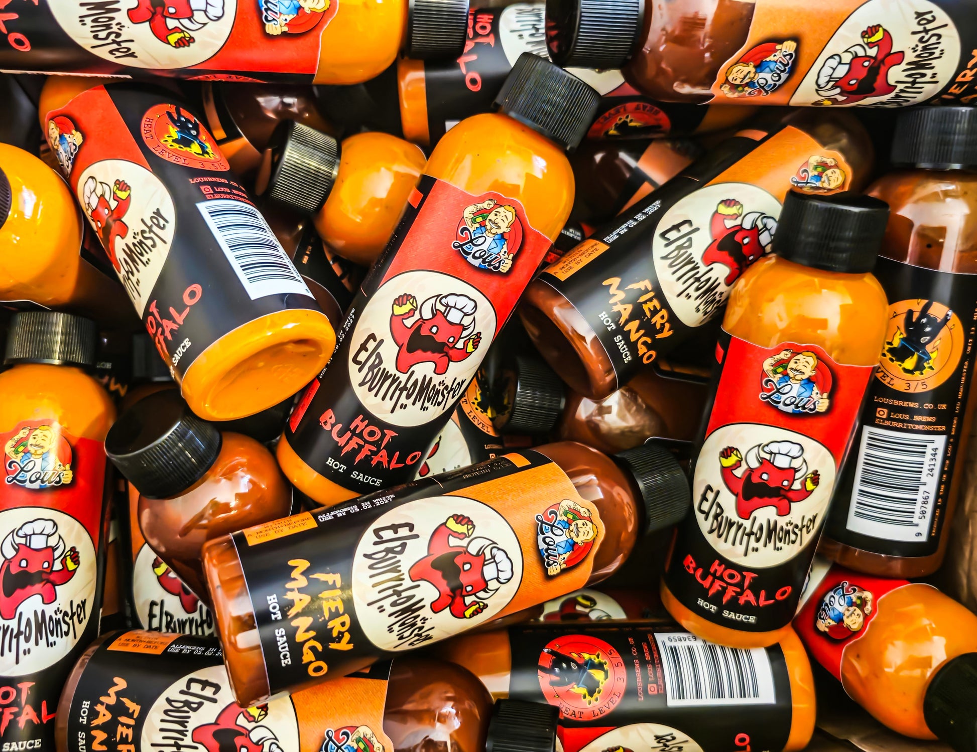 Fiery Mango Hot Sauce by Lou's Brews in a colorful bottle, featuring a monster-themed label, perfect for spicy condiment lovers.