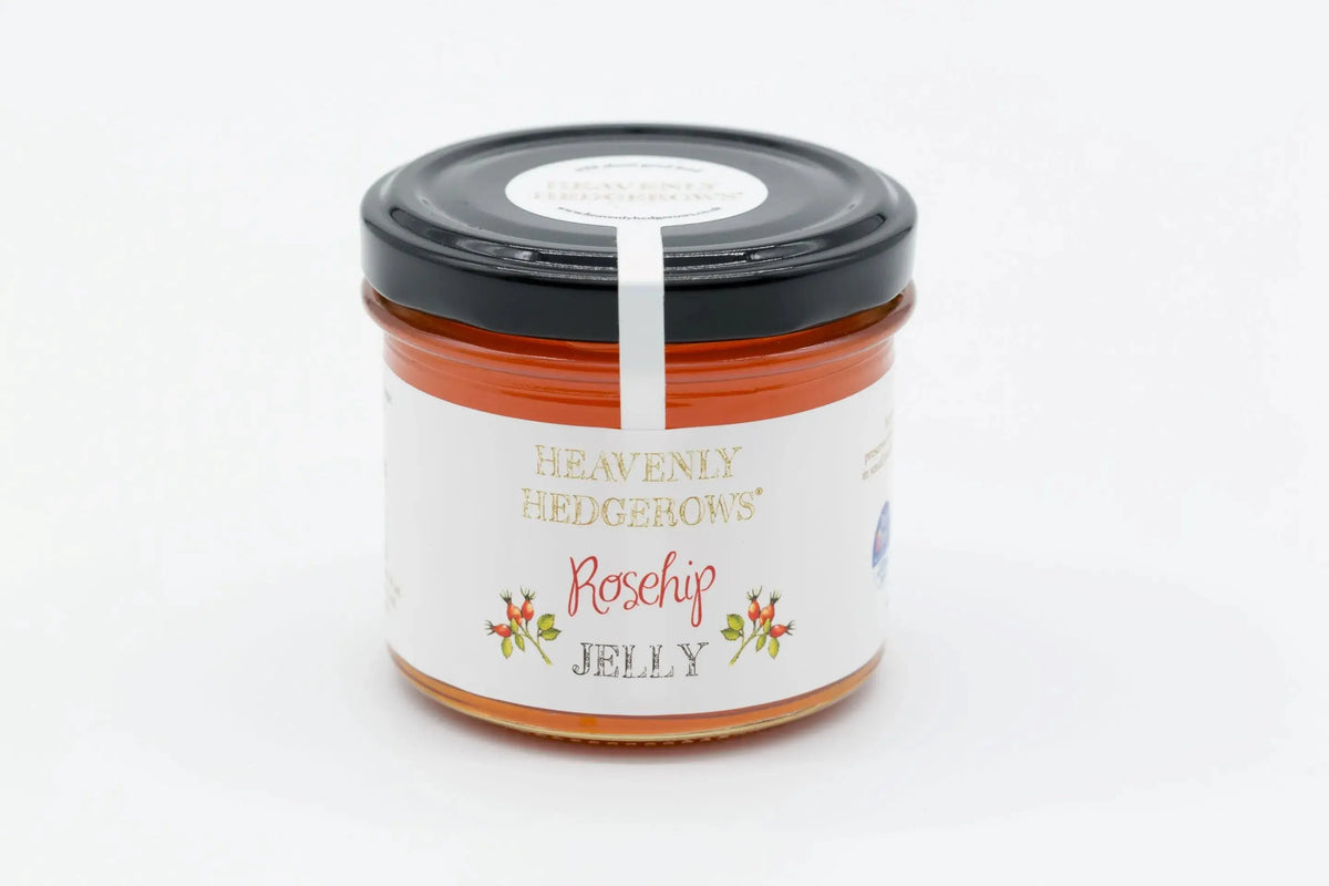 Heavenly Hedgerows rosehip jam spread on a toast slice, showing vibrant orange-red jelly with fresh rosehips in the background.