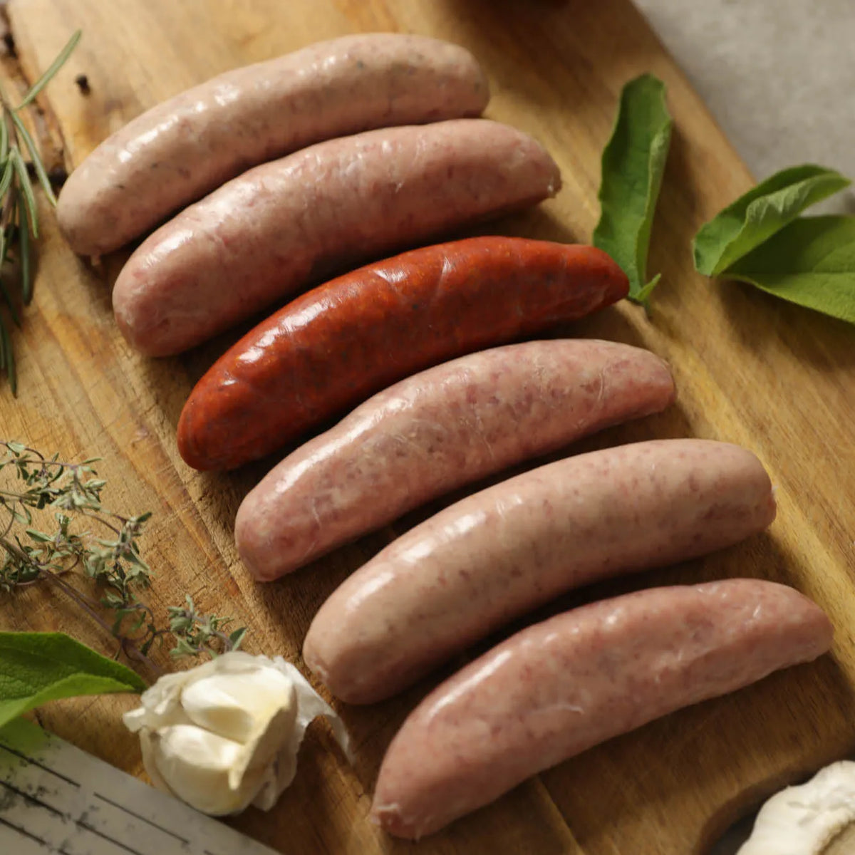 Assorted Cornish Heritage Pork sausages from Primrose Herd in a meat box, showcasing a variety of fresh, handcrafted sausages.