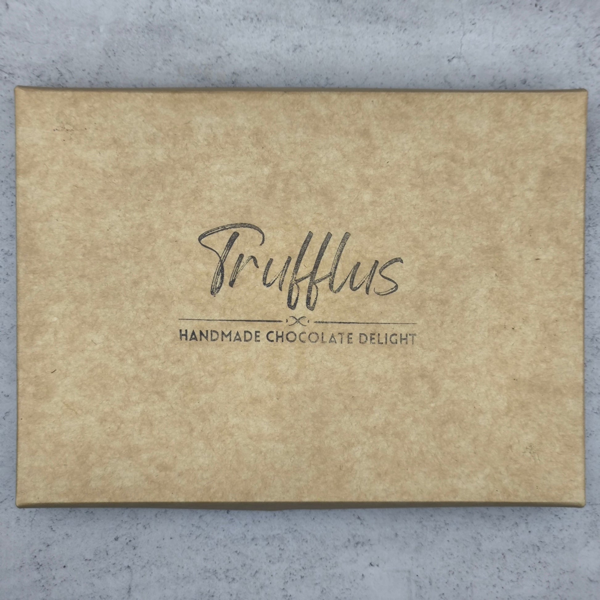 Trufflus chef's selection of 24 artisan bonbons arranged in a decorative box, showcasing a variety of colorful, handcrafted chocolates.