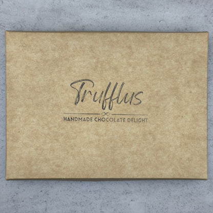 Trufflus chef's selection of 24 artisan bonbons arranged in a decorative box, showcasing a variety of colorful, handcrafted chocolates.