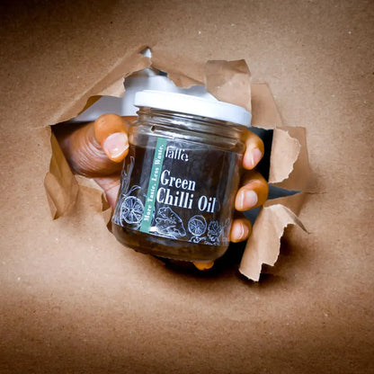 A bottle of Laffe Sustainable Green Chilli Oil with fresh green chillies and vibrant oil inside, highlighting the product's natural ingredients.