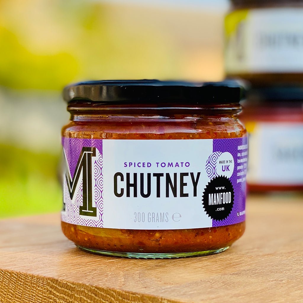 Manfood Spiced Tomato Chutney jar showcasing vibrant, chunky tomato chutney with spices in a clear glass jar.