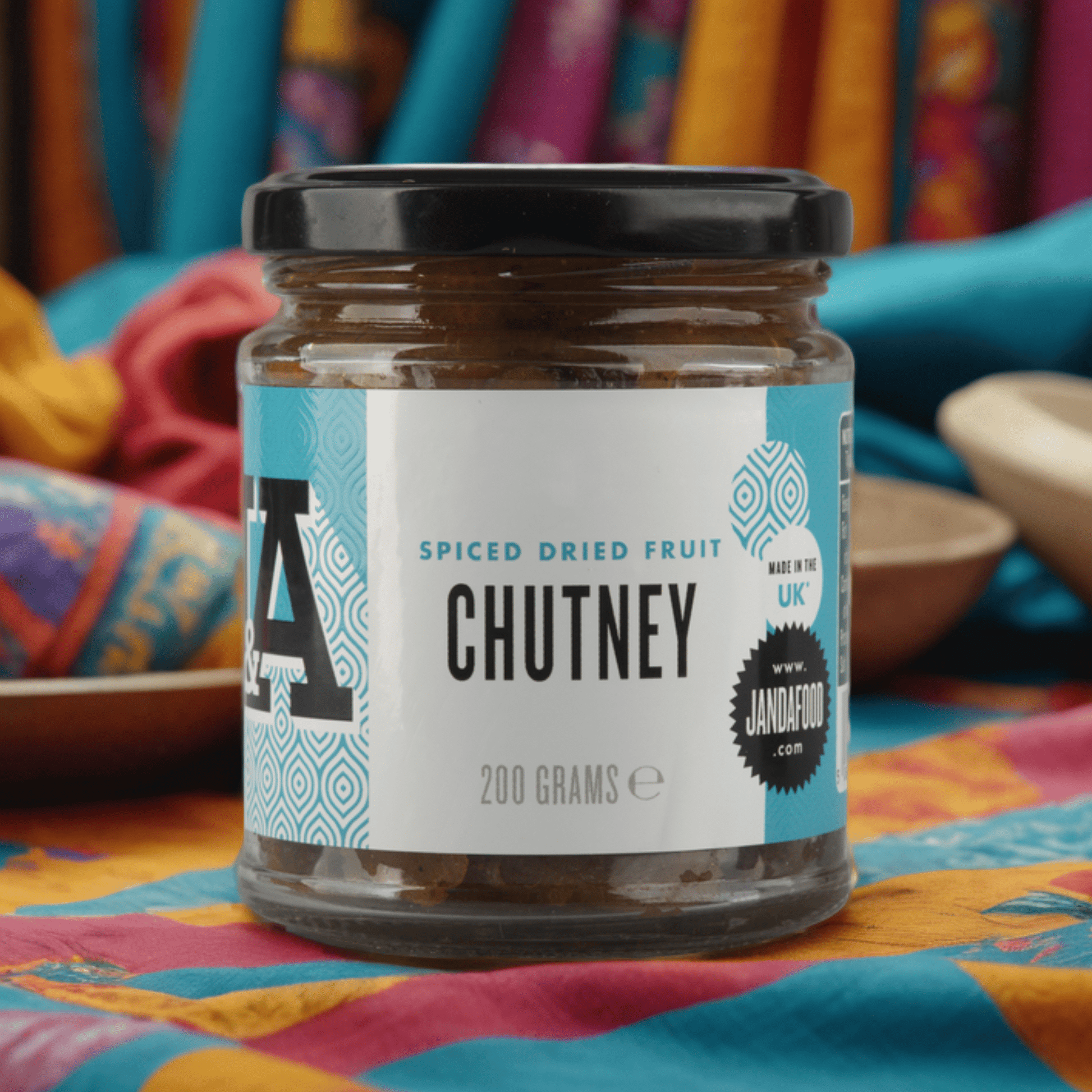 J&A Spiced Dried Fruit chutney on a colourful cloth background