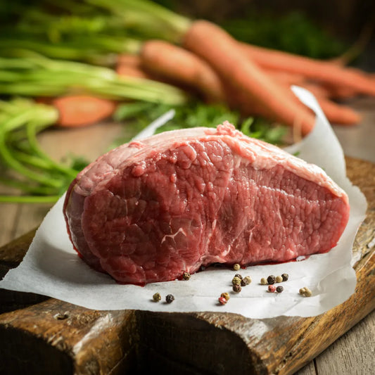 Prime grass-fed beef topside joint from Primrose Herd, showing a fresh beef cut with marbling and trimmed edges.
