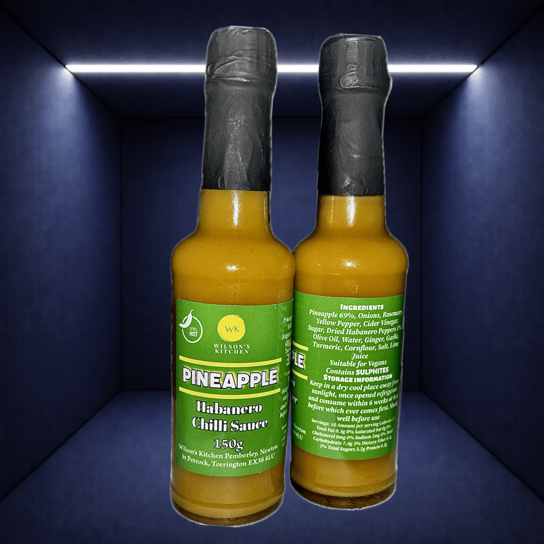 Wilson’s Kitchen Pineapple Habanero Sauce in a glass bottle, showcasing vibrant yellow pineapple and fiery habanero peppers.