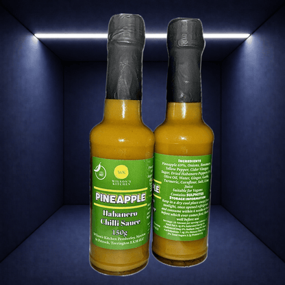 Wilson’s Kitchen Pineapple Habanero Sauce in a glass bottle, showcasing vibrant yellow pineapple and fiery habanero peppers.