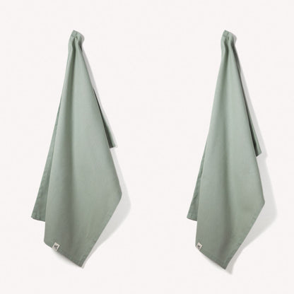Set of two Wild and Stone organic cotton tea towels with herringbone weave, perfect for kitchen use and drying dishes.