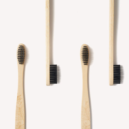 Adult bamboo toothbrushes with firm bristles in a 4-pack by Wild And Stone, showcasing eco-friendly toothbrushes with natural bamboo handles.