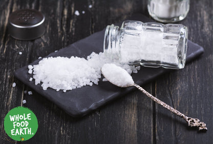 Coarse sea salt from Whole Food Earth, unrefined, GMO-free, vegan, and dairy-free mineral salt in a clear container.