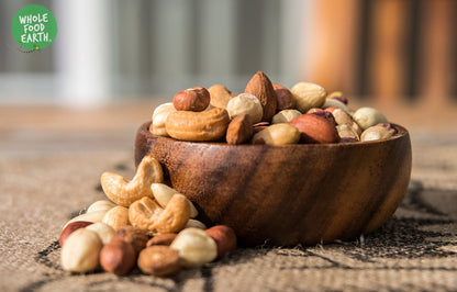 Assorted Whole Food Earth Deluxe Mixed Nuts featuring almonds, cashews, and walnuts in a natural, GMO-free, vegan, dairy-free mix.