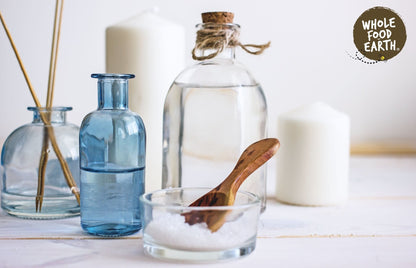 Additive-free Epsom Bath Salts from Whole Food Earth, showing white mineral salts in a clear container for relaxing bath soak.