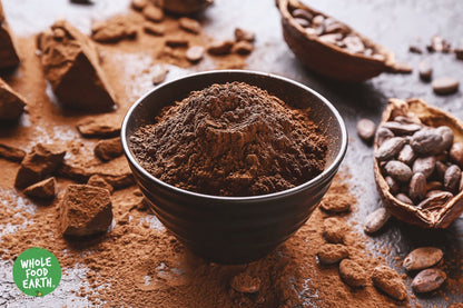 Organic alkalised cocoa powder in a container, showing a natural brown color, labeled as Whole Food Earth specialty vegan cocoa powder.
