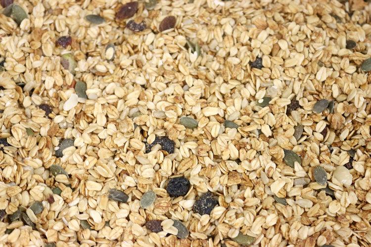 Organic Deluxe Muesli cereal by Whole Food Earth with flakes, nuts, seeds, and dried fruit in a bowl.