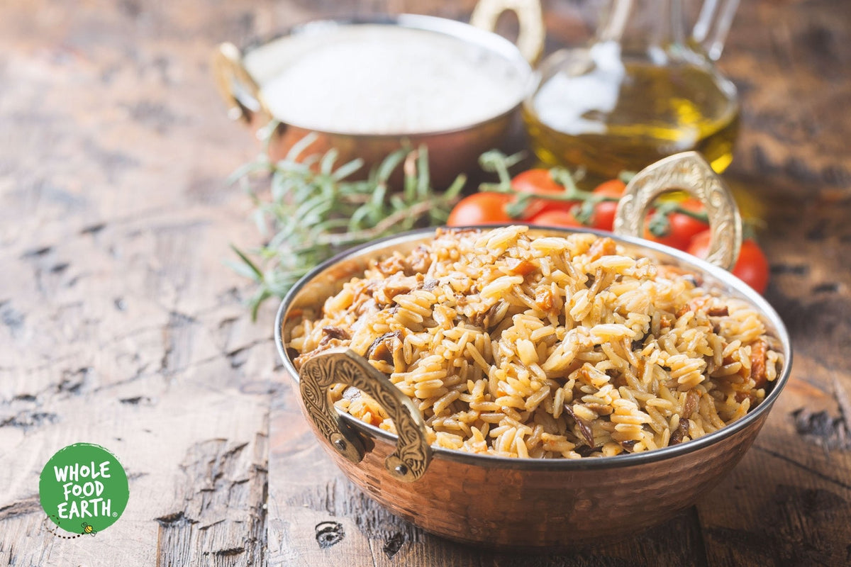 Organic long grain brown rice from Whole Food Earth, GMO-free, showing a close-up of uncooked rice grains in a bowl.