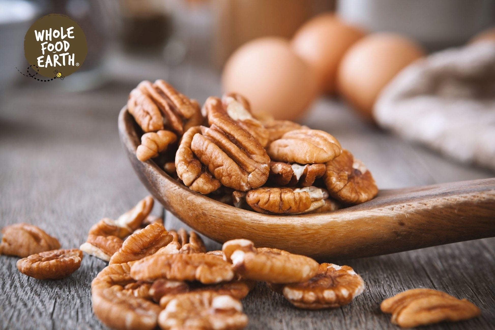 Raw Whole Food Earth pecan halves, GMO-free nuts and seeds, showing light brown, crunchy pecan pieces on a neutral background.
