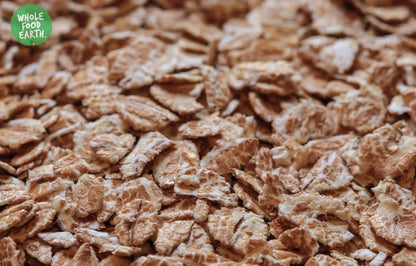 Plain toasted wheat flakes cereal by Whole Food Earth, GMO-free, vegan, dairy-free, no added sugar, in a clear bowl.