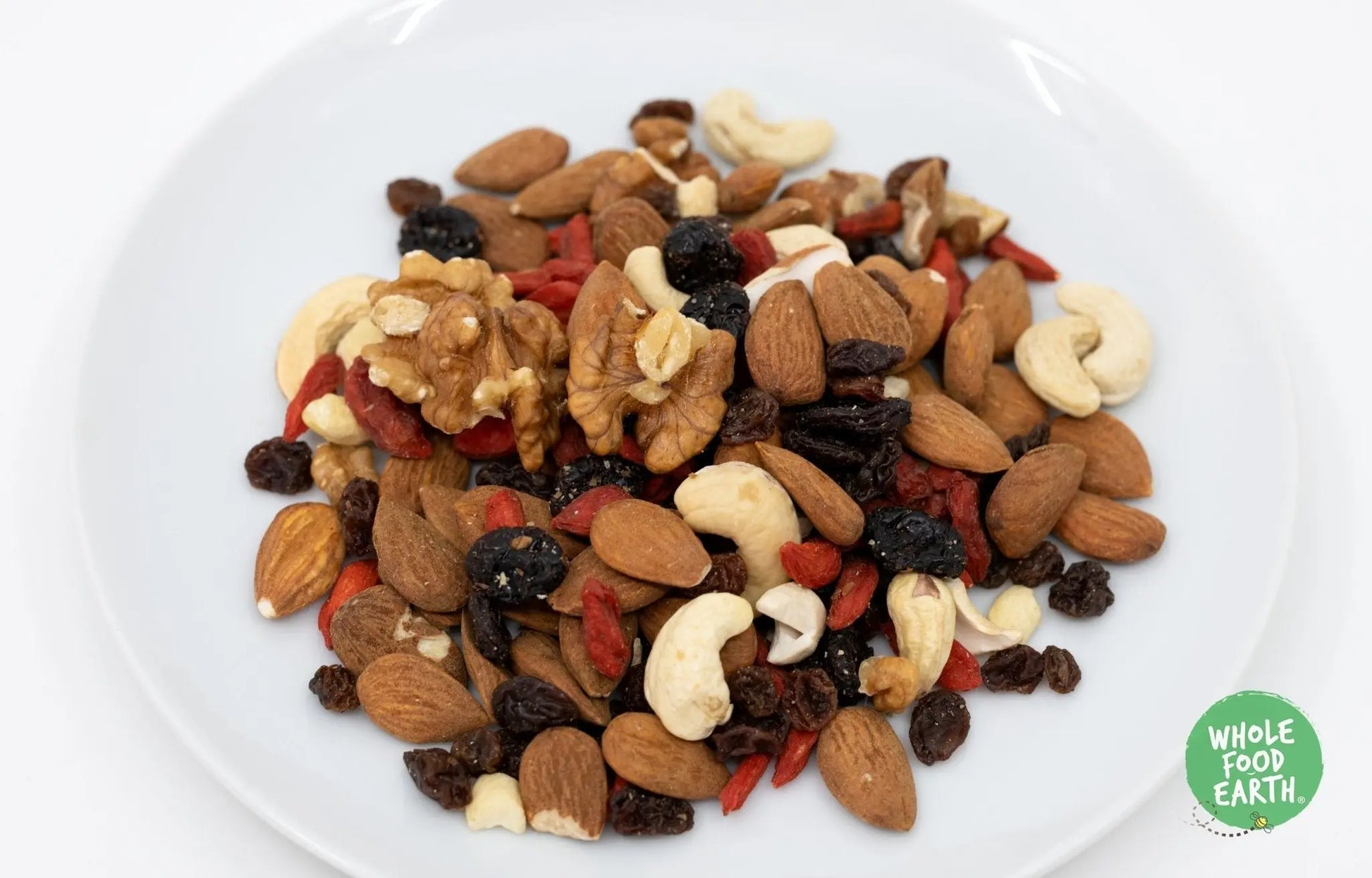 Whole Food Earth premium fruits and nuts mix for cakes, featuring colorful dried fruits and mixed nuts, GMO-free and vegan.