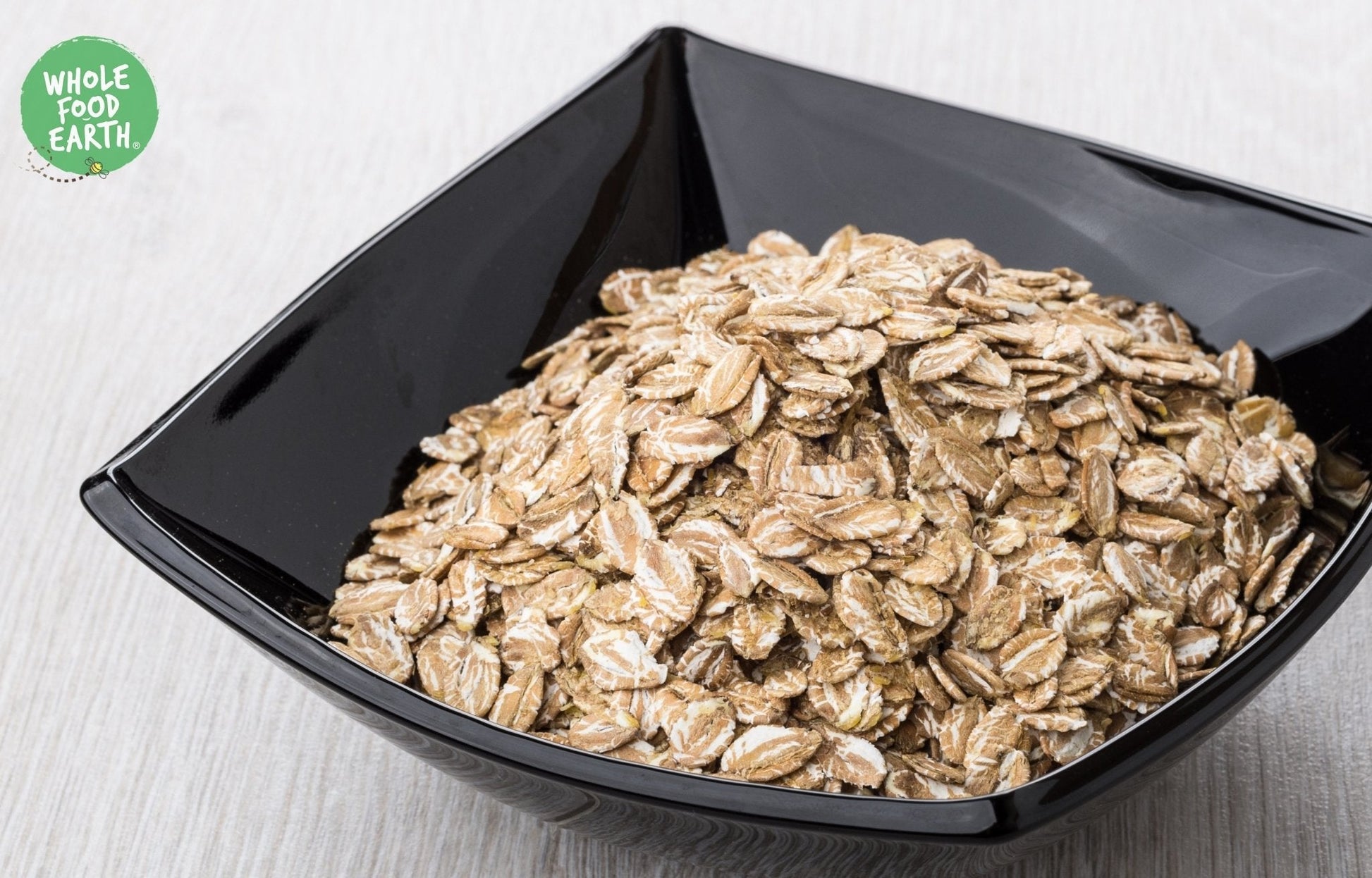 Whole Food Earth rye flakes, GMO-free, vegan, dairy-free, no added sugar, specialty cereal in a clear bowl.
