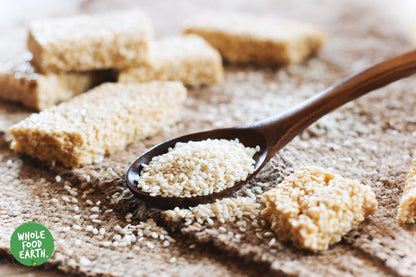 Hulled sesame seeds from Whole Food Earth, GMO-free, vegan, dairy-free, and no added sugar, shown in a close-up image.