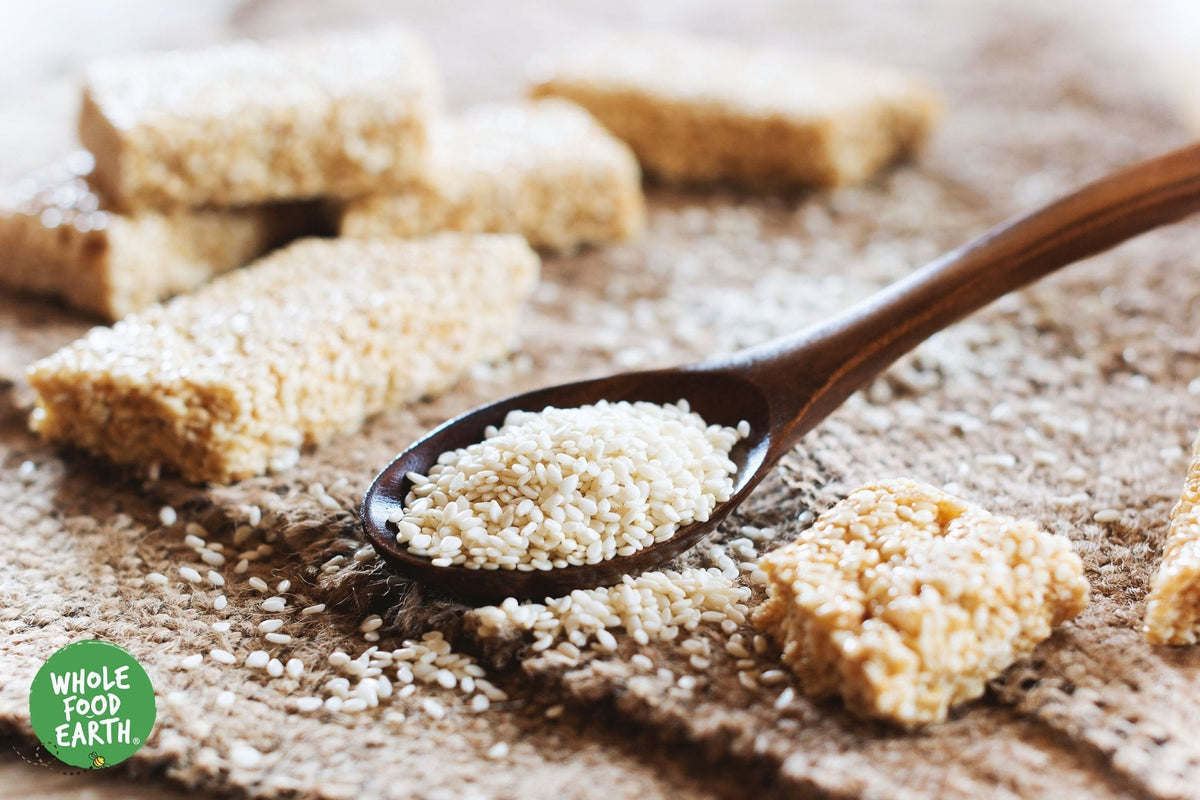 Unhulled sesame seeds from Whole Food Earth, natural and GMO-free, shown in a close-up image, ideal for cooking and baking.