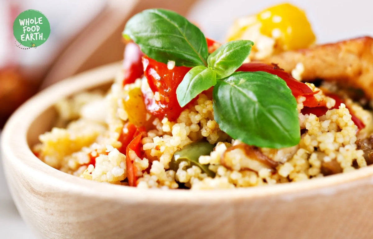 Whole Food Earth wholemeal couscous in a bowl, showcasing its textured, golden grains; GMO-free, vegan, dairy-free, no added sugar.