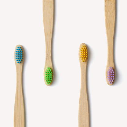 Colorful children’s bamboo toothbrushes from Wild And Stone, eco-friendly and suitable for kids, in a 4-pack with vibrant multi-color handles.
