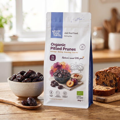 A bowl of organic pitted prunes by Whole Food Earth, showcasing dried fruits with a rich, chewy texture on a rustic wooden surface.
