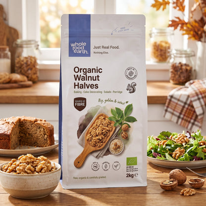 Organic walnut halves from Whole Food Earth, displayed in a bowl with scattered nuts on a wooden surface.
