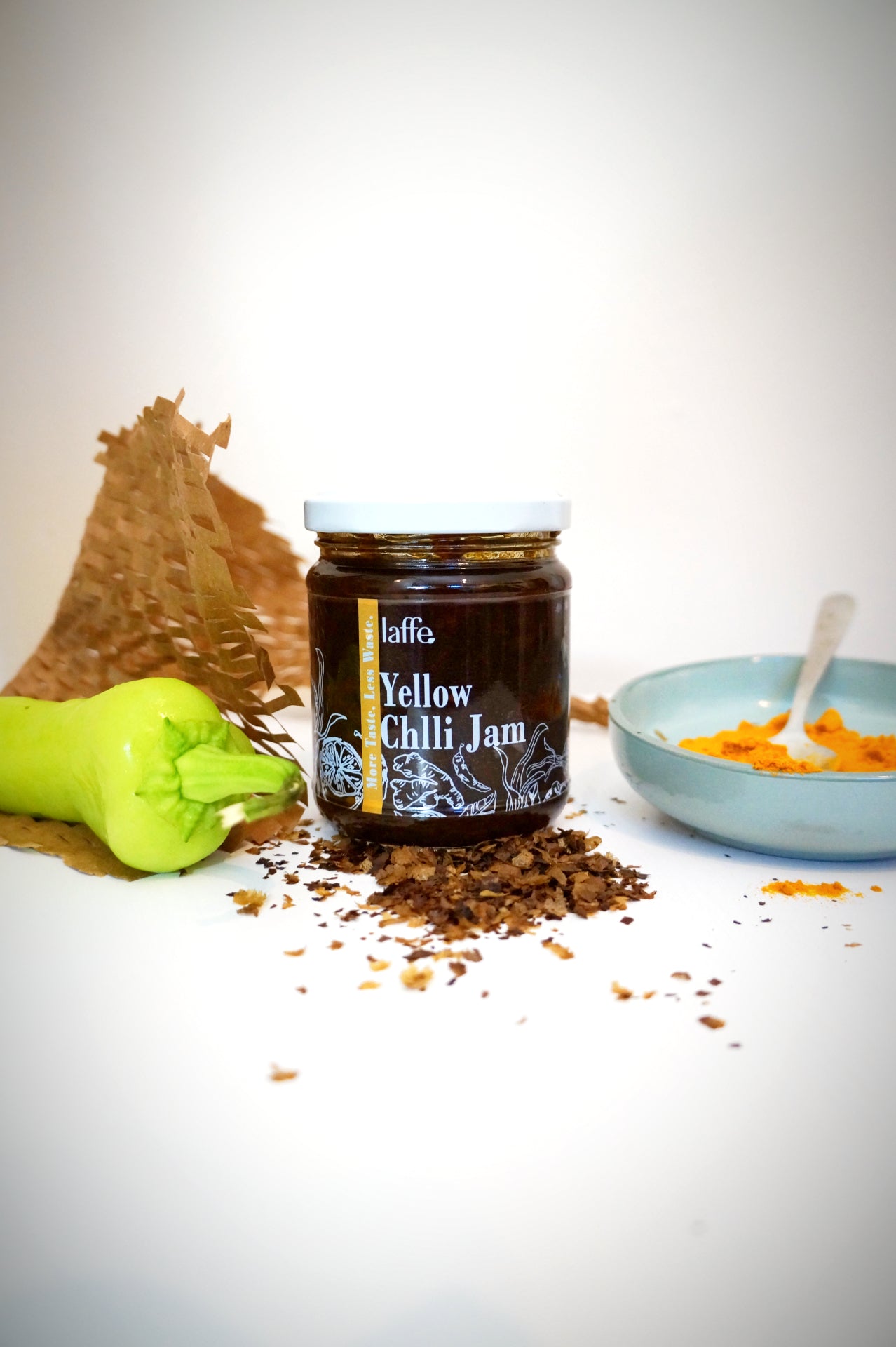 Laffe sustainable yellow chili jam in a jar, vibrant yellow color, smooth chili sauce with fresh chili ingredients visible